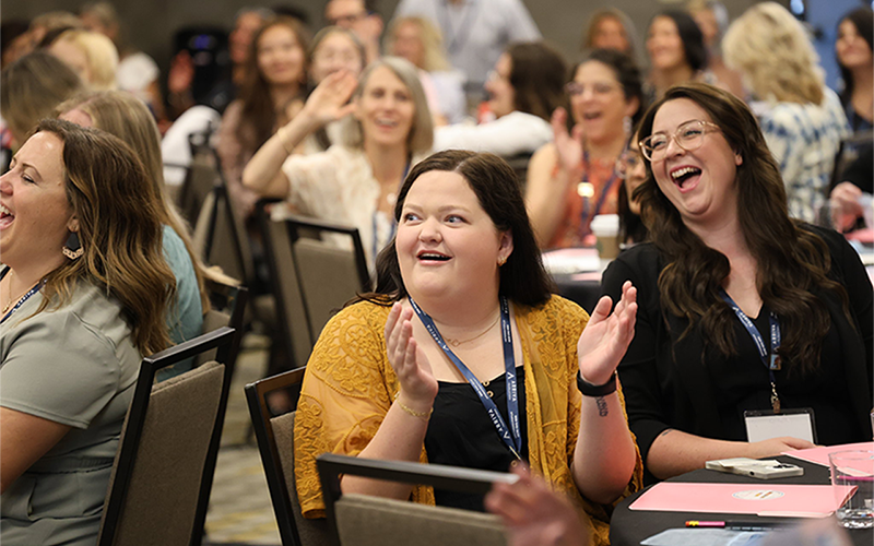 Conference attendees laughing during session